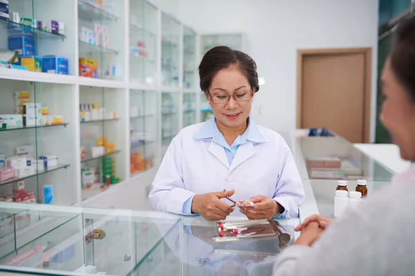 Farmacista che vende pillole al cliente — Foto Stock