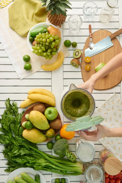 Kvinnan gör grön smoothie — Stockfoto