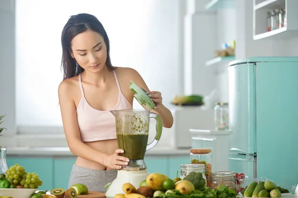 Woman making smoothie for breakfast