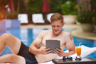 Yüzme Havuzu yalan sırasında dijital tablet kullanan adam