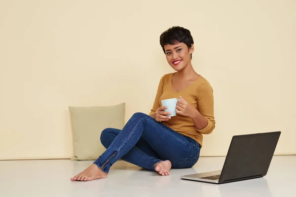 Frau mit Tasse Tee und Laptop — Stockfoto