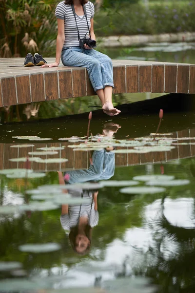 Girl resting by pond in park — Stock Photo, Image