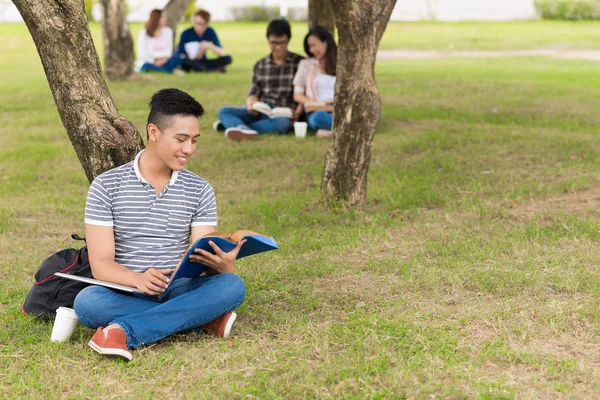 Student sitter och läser bok — Stockfoto