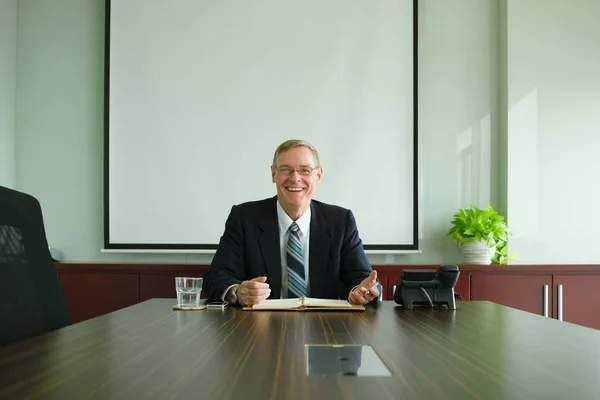 Businessman sitting at table in office — Stock Photo, Image