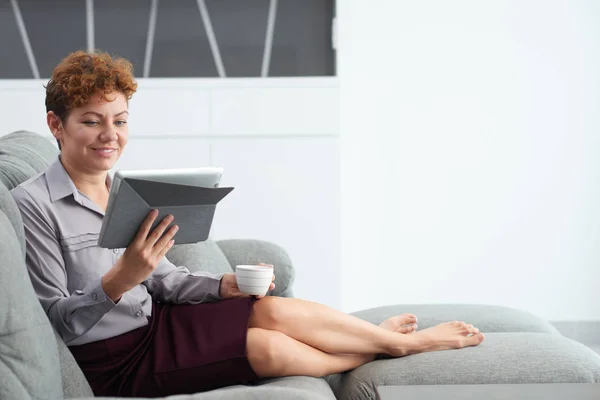 Kvinna läser på tablet PC — Stockfoto