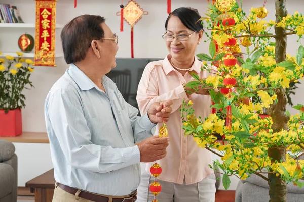 Aged couple putting traditional decorations — Stock Photo, Image