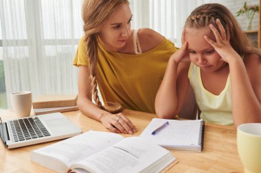 Anne kızına ev ödevinde yardım ediyor.