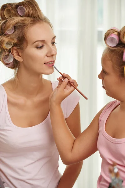 Fille appliquant maquillage à la mère — Photo