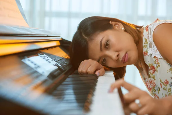 Vrouw leunend op piano — Stockfoto