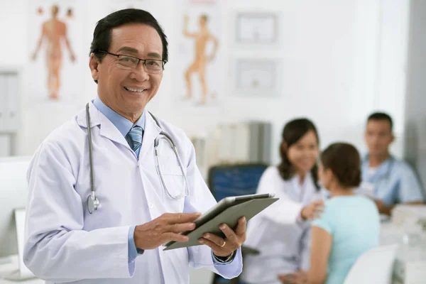 Médico sorridente com computador tablet — Fotografia de Stock