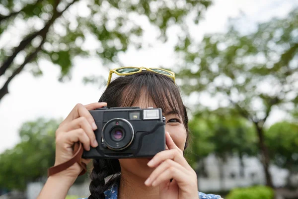Menina tirando fotos com câmera vintage — Fotografia de Stock