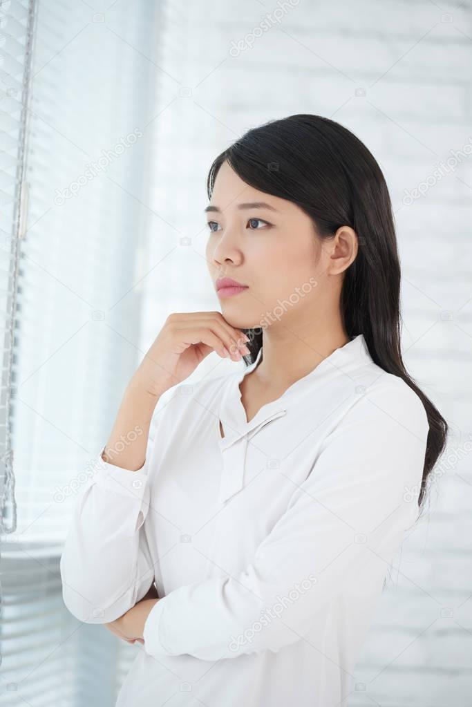 business woman contemplating in window