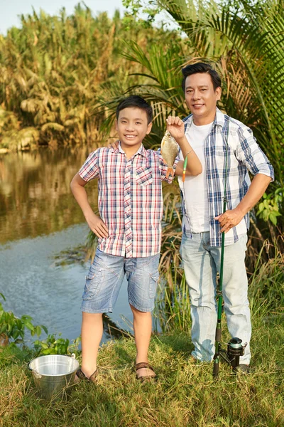 Homem e menino de pé com peixes — Fotografia de Stock