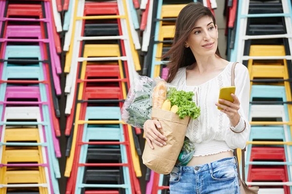 Kvinna innehav väska med produkter — Stockfoto