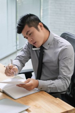 işadamı smartphone üzerinde konuşurken notlar yapma