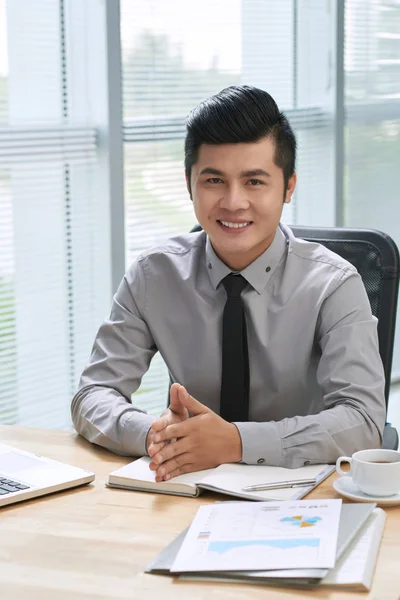 Empresário sorridente sentado na mesa — Fotografia de Stock