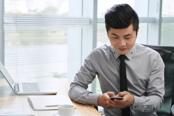 Podnikatel SMS na svůj smartphone — Stock fotografie