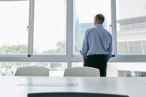 Entrepreneur looking through window — Stock Photo, Image