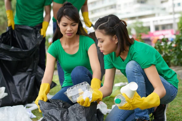Amigos do sexo feminino pegando lixo doméstico — Fotografia de Stock