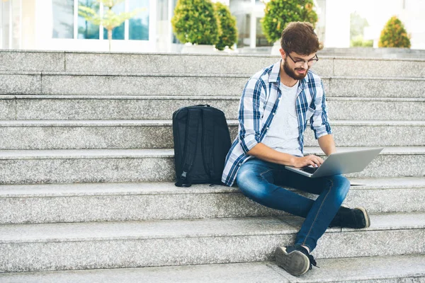 学生男屋外階段の上に座って ノート パソコンに取り組んで — ストック写真