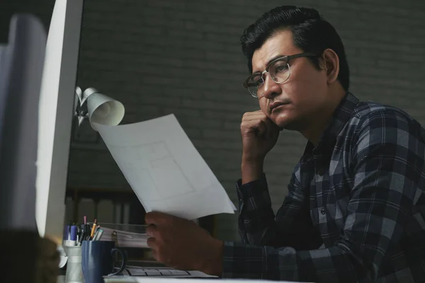 Συλλογισμένος Ασίας Άνθρωπος Εξετάζοντας Σχέδιο Χαρτί Οικοδομική Βιομηχανία — Φωτογραφία Αρχείου