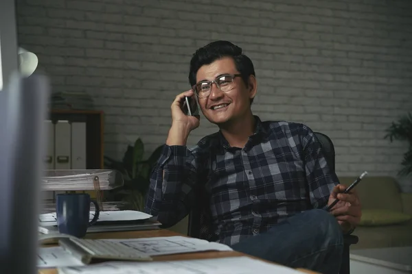 微笑的亚洲商人坐在他的桌子和打电话 — 图库照片