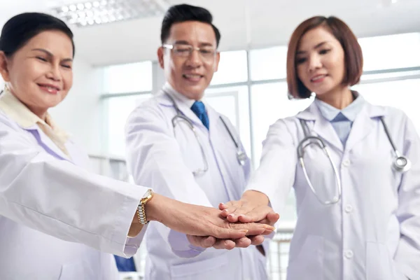 仕事の日の前にお互いにサポートするアジア医師の手をスタッキング — ストック写真