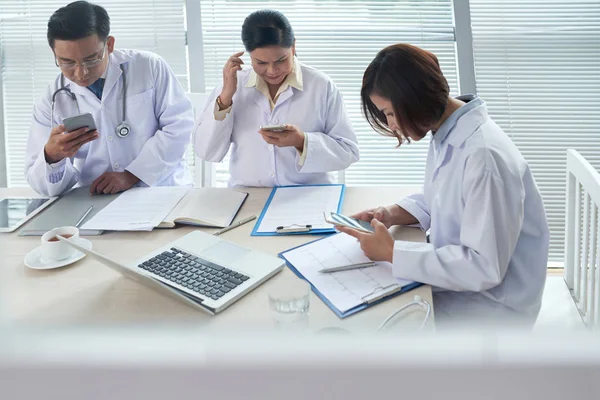 Ärzte Checken Während Der Besprechung Ihre Telefone — Stockfoto