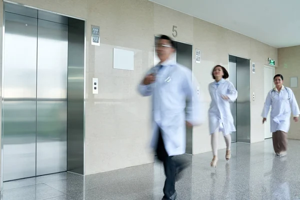 Doctors walking in hall on hospital building, blurred motion