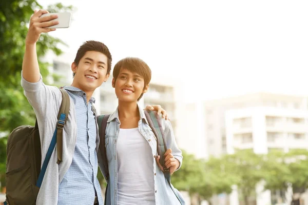 Two Cheerful Asian Friends Backpacks Taking Selfie Smartphone While Walking — Stock Photo, Image
