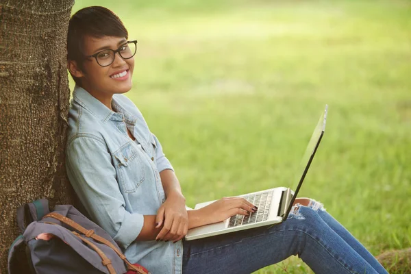 Vrolijke Universiteitsstudent Bril Camera Kijken Terwijl Het Doen Van Huiswerk — Stockfoto