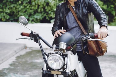 siyah deri ceketli ve motosiklet üzerinde oturan motorcu adam