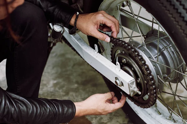 Onherkenbaar Motorrijder Zittend Lendestuk Aanpassing Van Keten Spanning Close Shot — Stockfoto