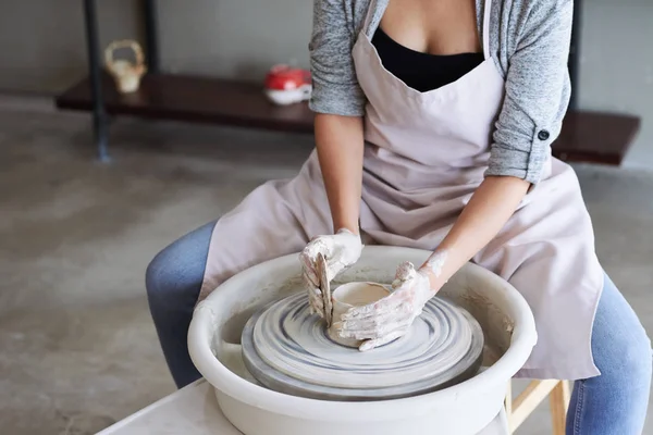 在车轮上制作陶瓷壶的年轻女子的裁剪图像 — 图库照片