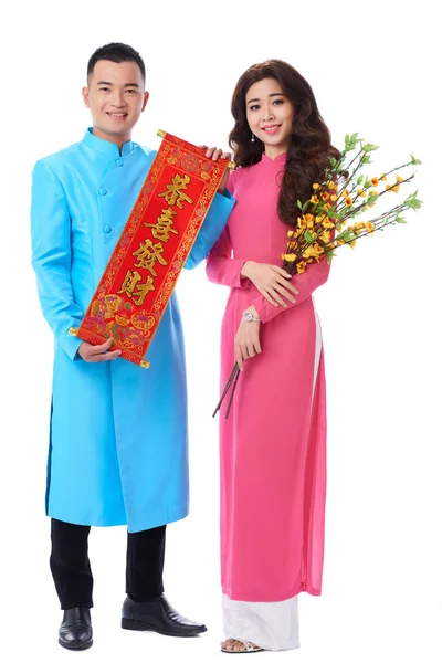 陽気なベトナム人カップルの伝統的な衣装を着て 手で旧正月の属性を保持 — ストック写真