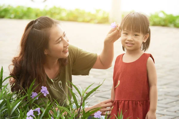 Smiling Asian Woman Putting Purple Flower Hair Her Daughter — Stock Photo, Image