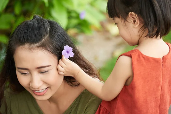 Mała Dziewczynka Oddanie Kwiat Włosach Matki — Zdjęcie stockowe