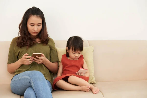 Vietnamese Young Woman Her Daughter Sitting Sofa Using Smart Phones — Stock Photo, Image