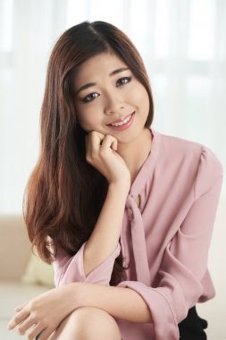 Kameraya bakarak ve gülümseyen çekici Vietnamca genç kadın