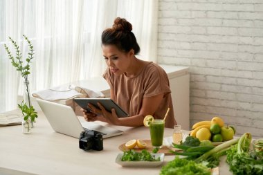 Onun blog için yemek tarifi arama genç kadın