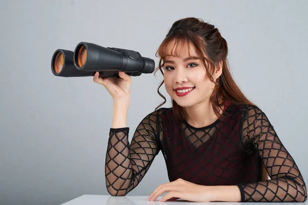 Portrait of pretty Asian woman with binoculars