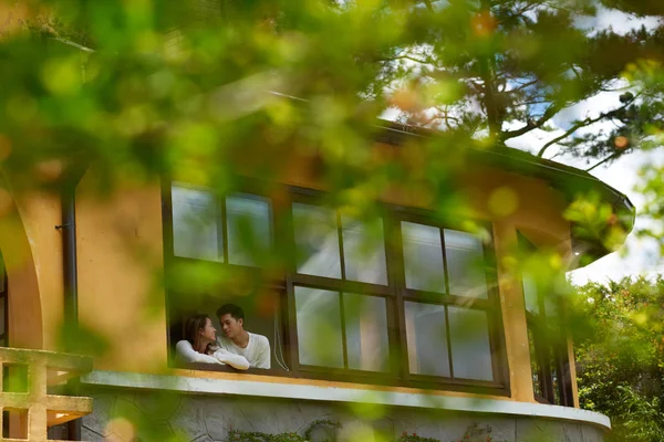 初期の秋の日に彼らの家のウィンドウで愛するアジア カップル — ストック写真