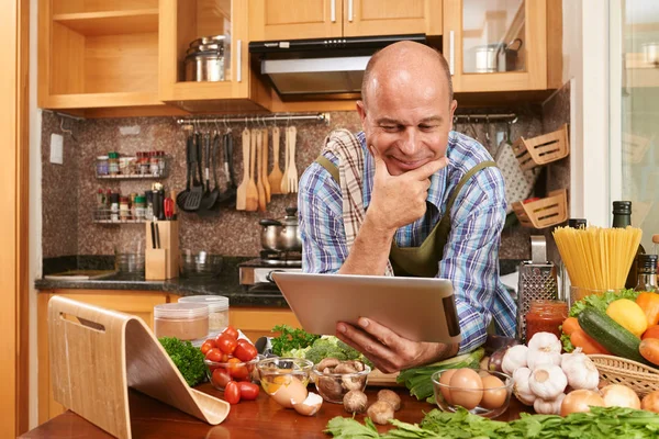 Lächelnder Mann Mittleren Alters Liest Rezept Auf Tablet Computer — Stockfoto