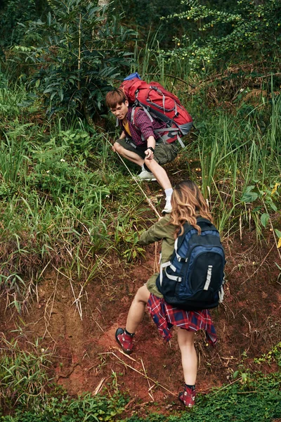 Asian Man Helping Woman Climb Hill Rope — Stock Photo, Image