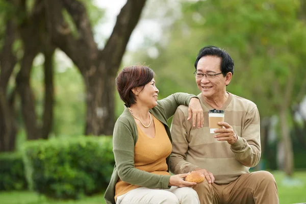 高级微笑的越南夫妇在公园里喝着咖啡和包子 — 图库照片