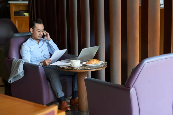 Азиатский Бизнесмен Звонит Телефону Читает Контракт Сидя Кафе — стоковое фото
