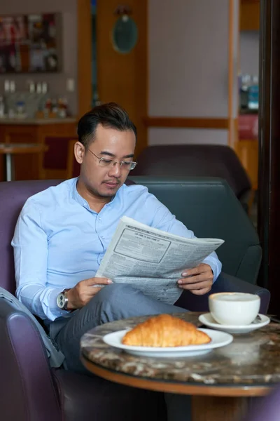 ハンサムなアジア系のビジネスマンの新聞を読むと Coffeshop でコーヒーを飲む — ストック写真