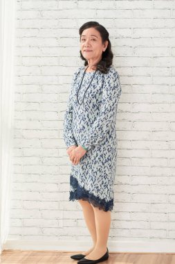 Kadın zarif güzel elbise ayakta beyaz tuğla duvar, Vietnamca gülümseyen oldukça kıdemli portresi