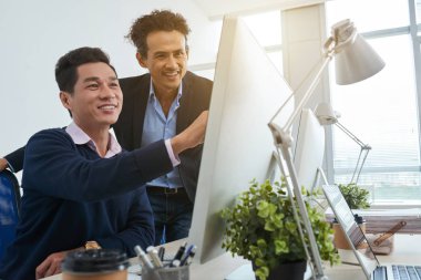 Bilgi bilgisayar ekranında tartışırken gülümseyen Vietnamca arkadaşları