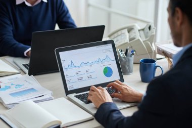 Diyagram dizüstü bilgisayar ekranında, analiz işadamı omuz üzerinden görünüm